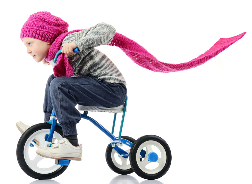 Young girl riding a tricycle